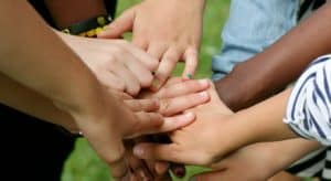 Menschen verschiedener Hautfarbe reichen sich die Hände.